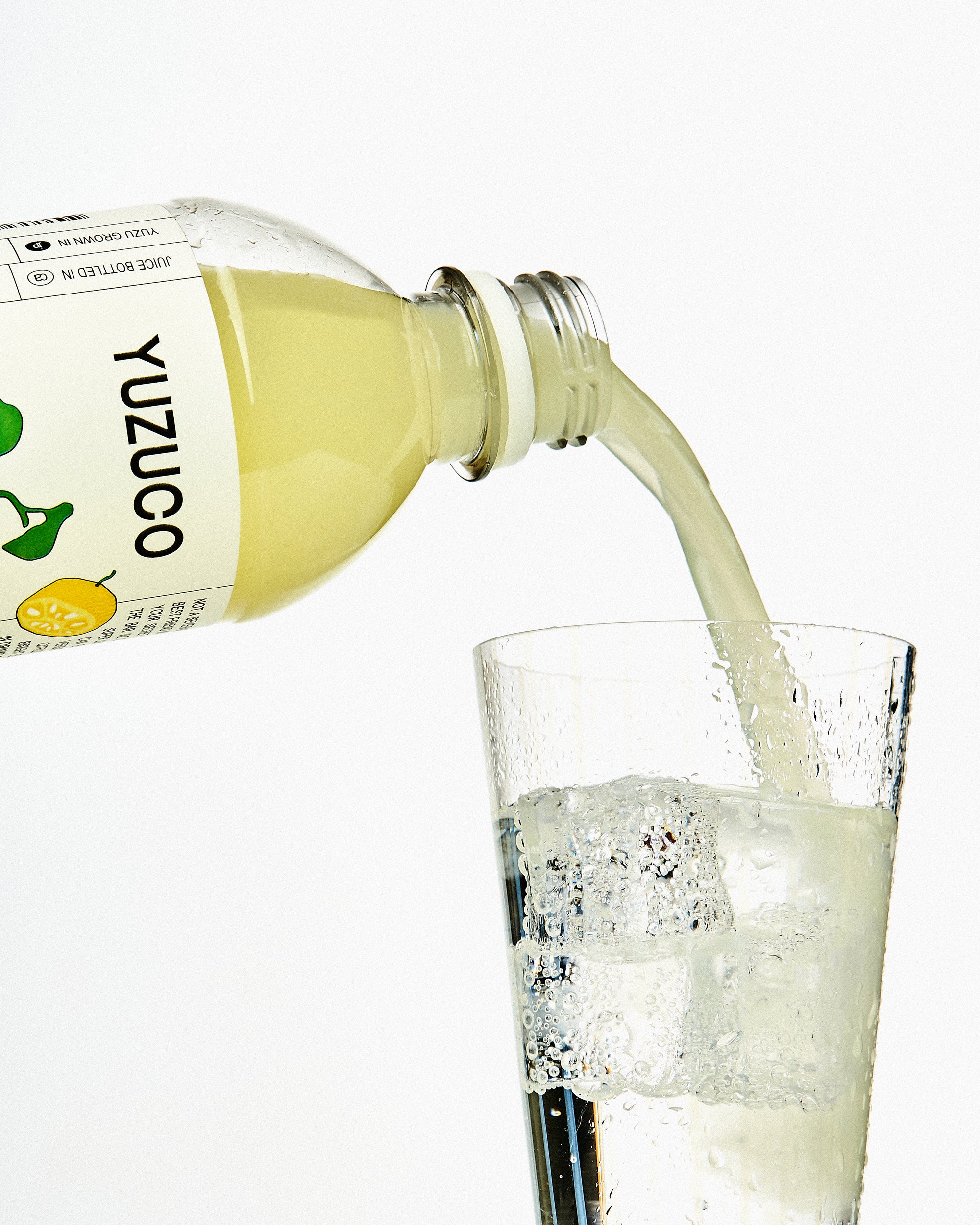 Pouring yuzu super juice into orion beer in sushi bar setting.