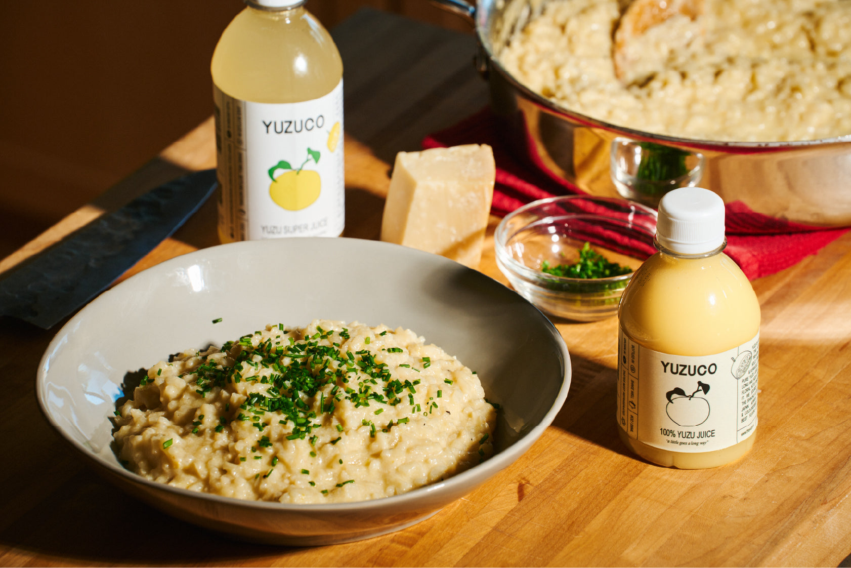 Yuzu Risotto in grey bowl next to yuzuco yuzu juice and yuzu super juice 