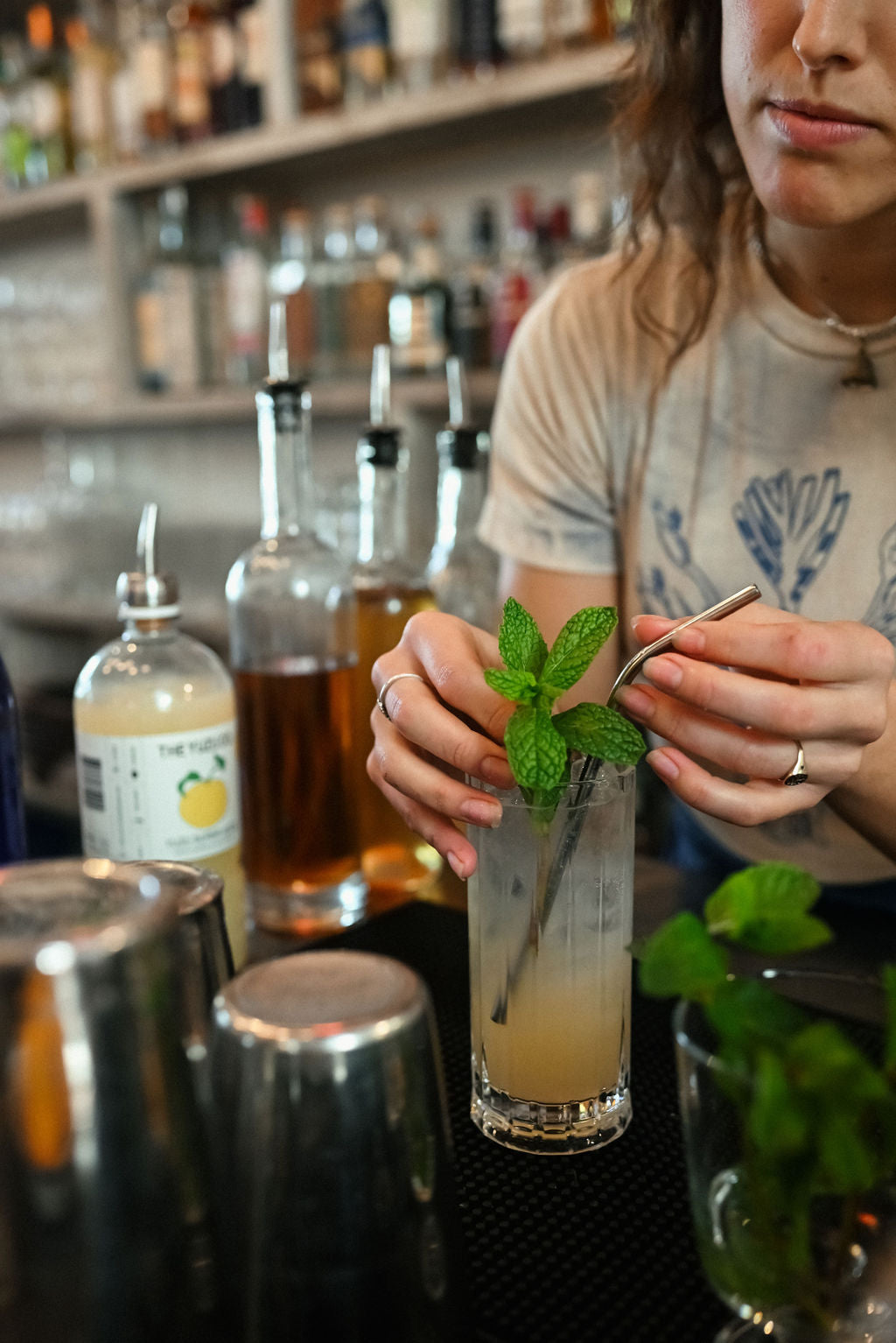 bartender adding mint garnish to yuzu spritz at botanica in los angeles
