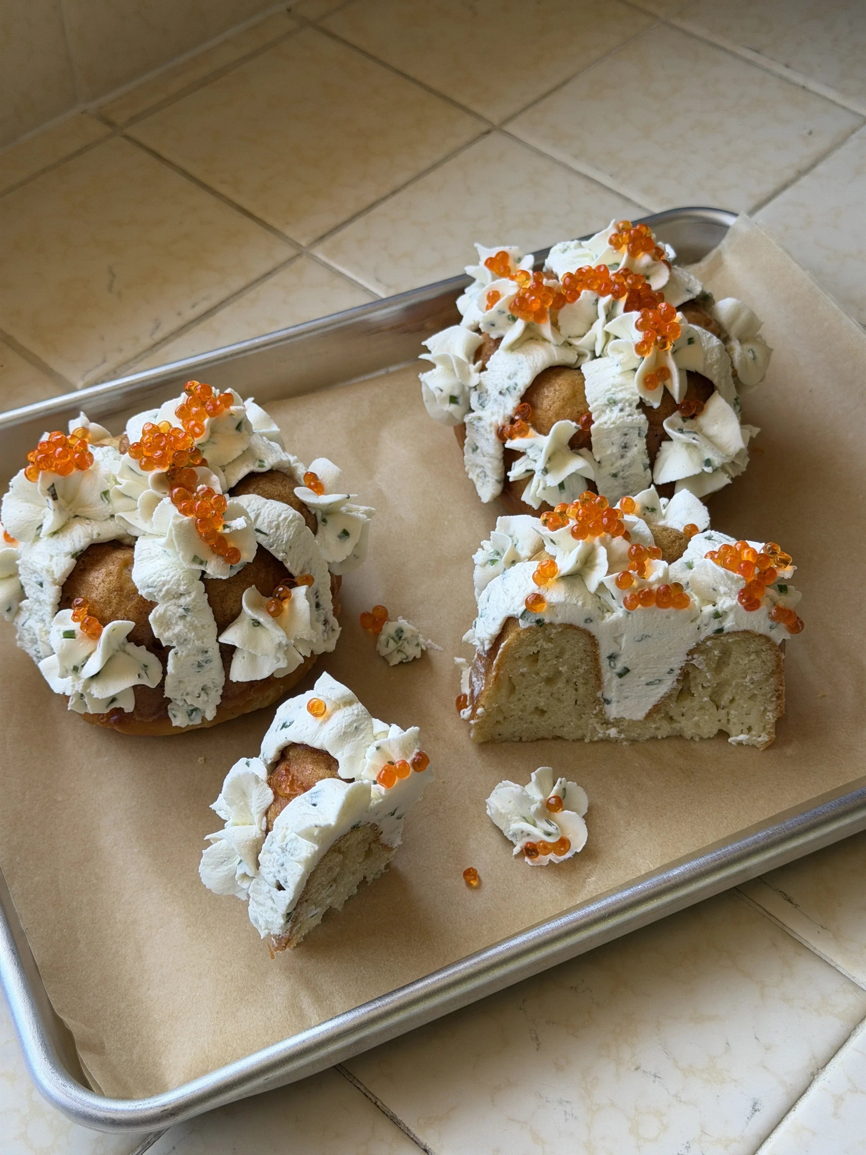 3 mini savory yuzu bundt cakes with smoked trout roe on parchment paper and silver platter