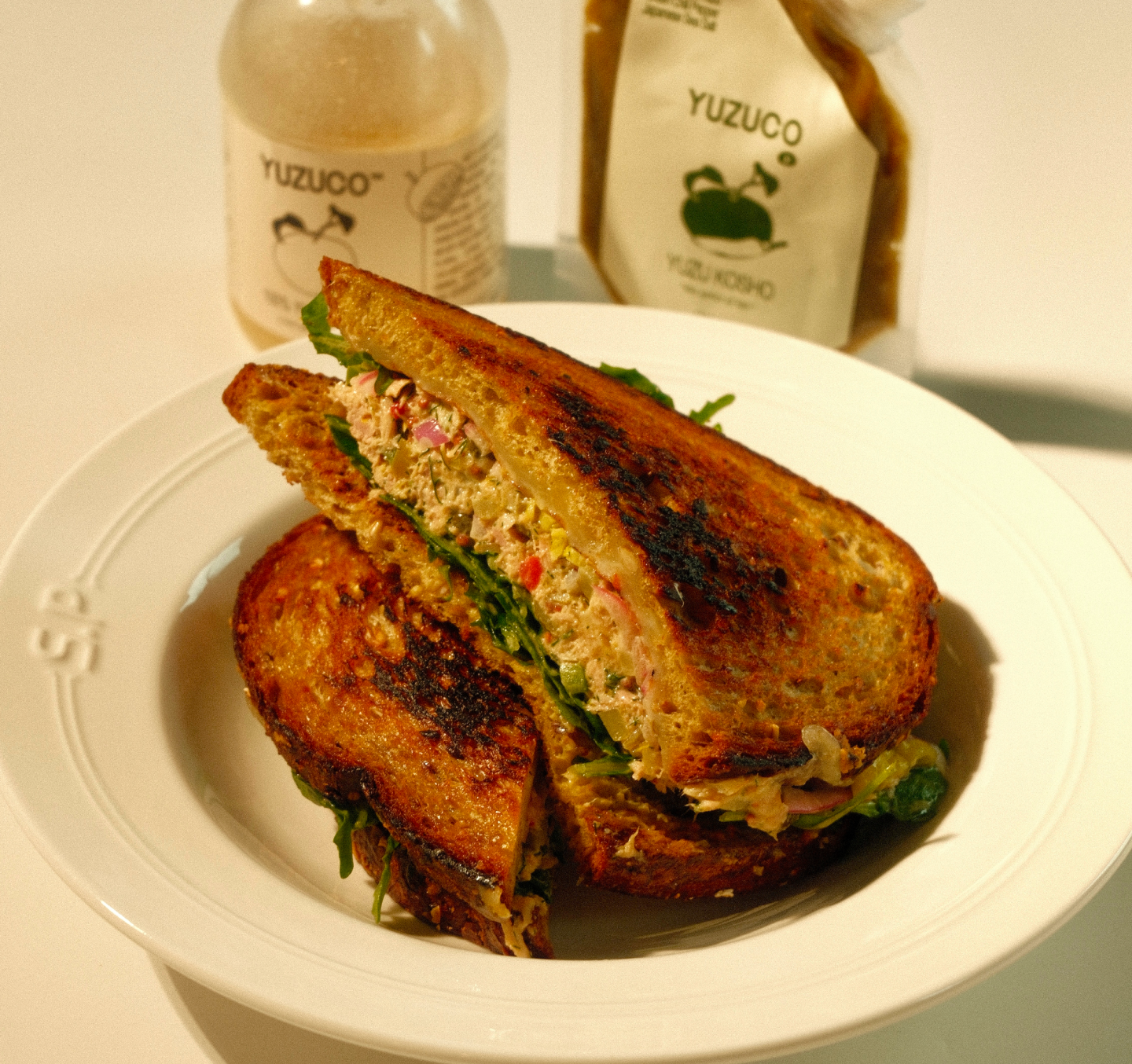 grilled tuna melt sandwich in a white dish and white background