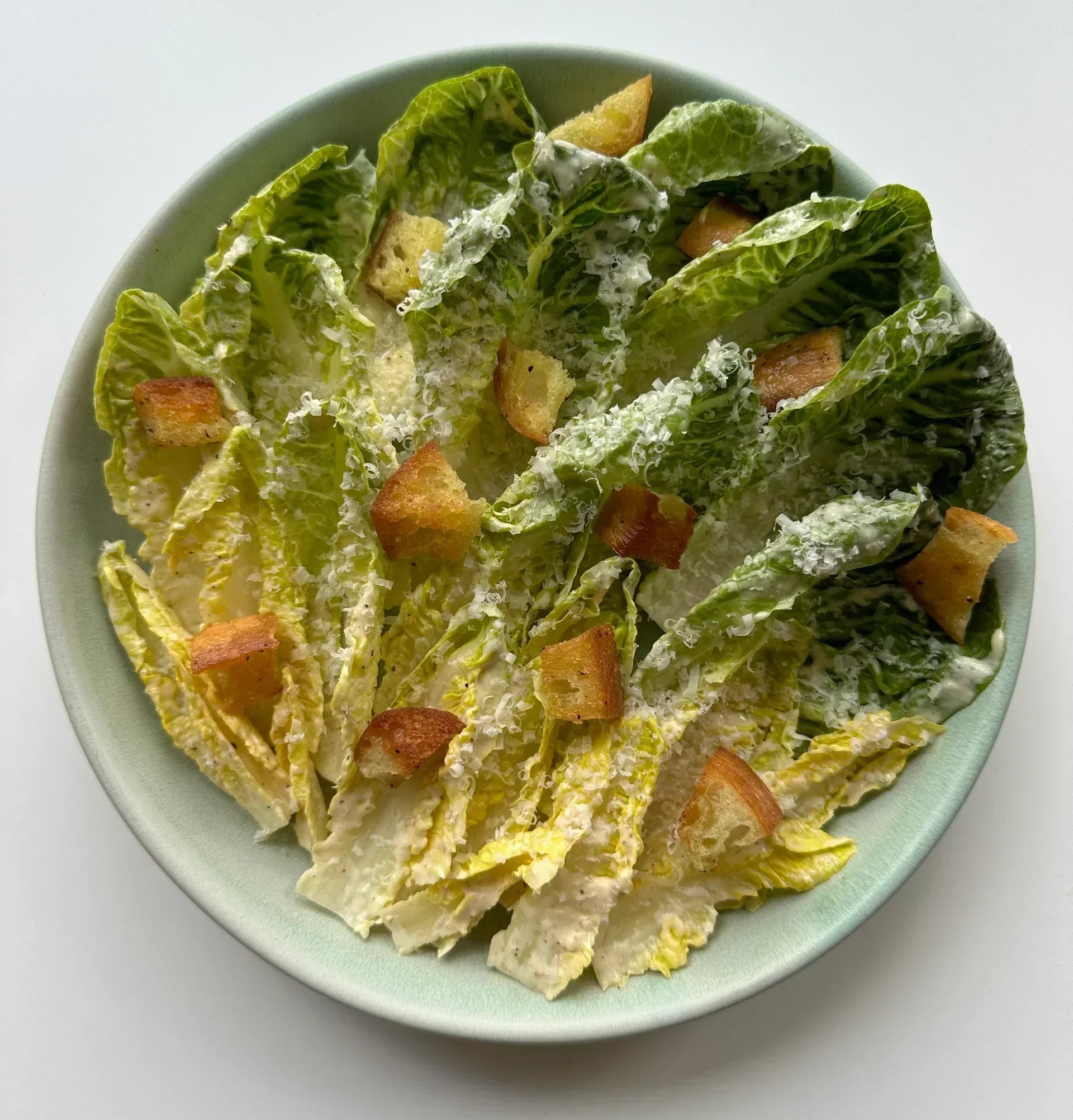 Caesar salad with romaine, croutons, parmesan, and a dressing containing yuzu juice, anchovy, and garlic.