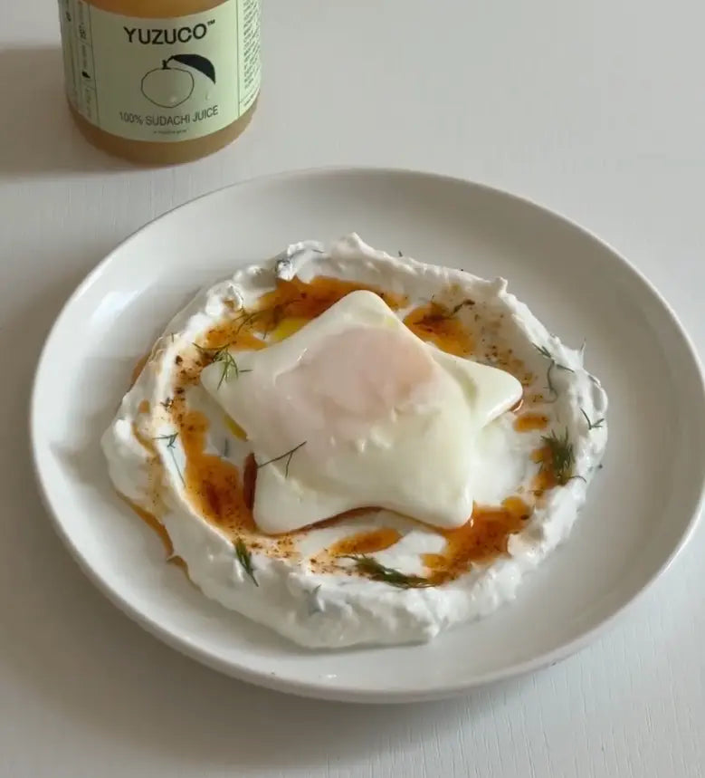 cibir with star shaped egg, topped with chili oil and dill on a white plate