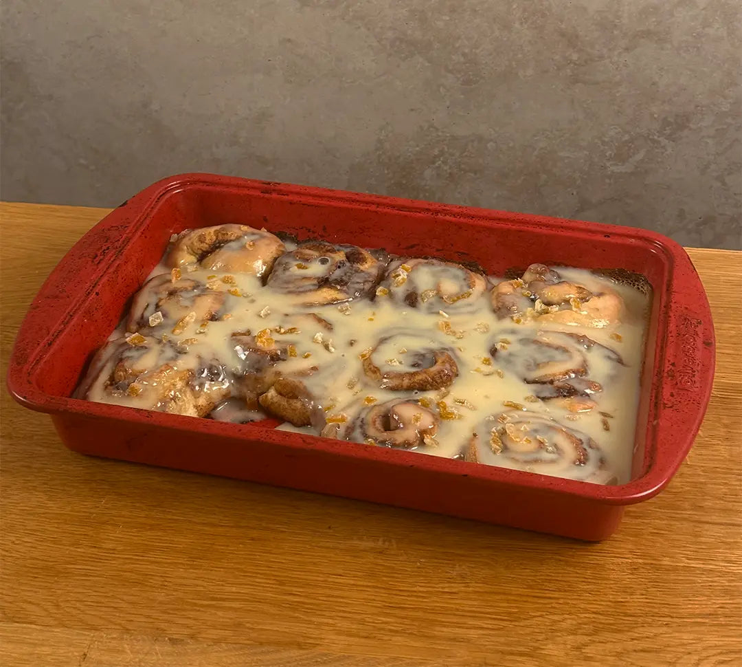 12 yuzu miso cinnamon rolls in a red baking pan