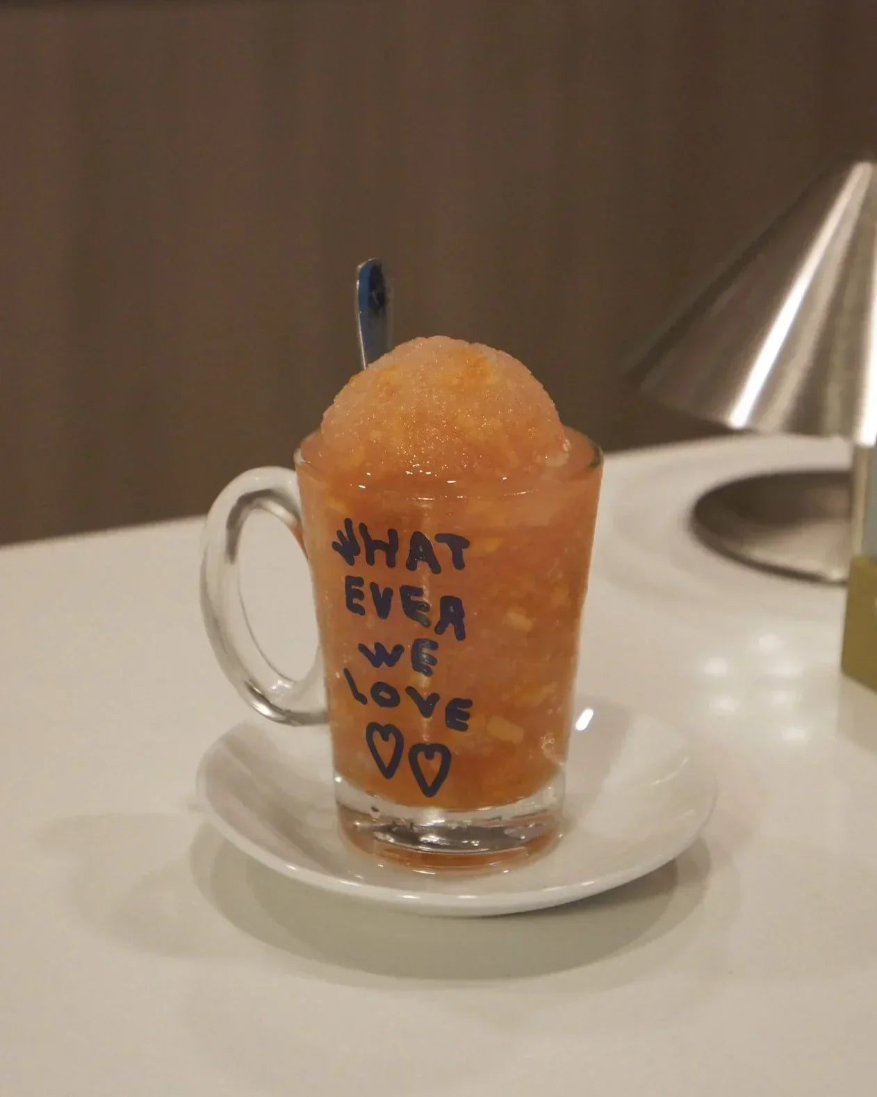 pink coconut guava yuzu slush with yuzu candied peel in a small glass with a handle