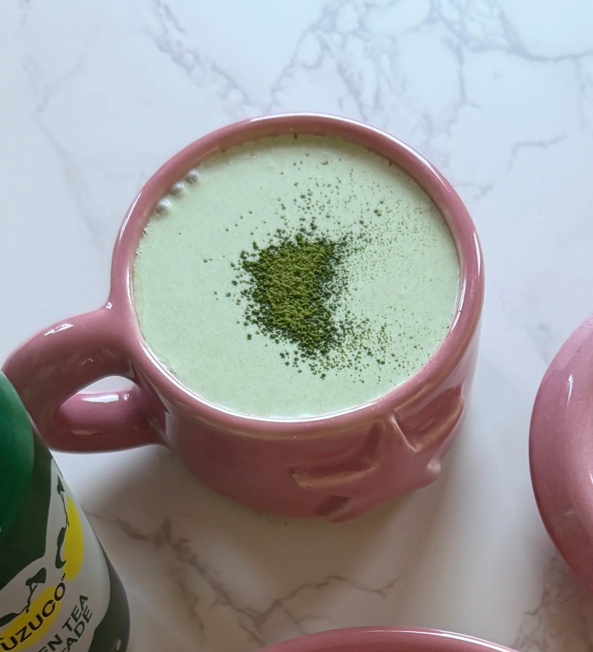 green tea yuzu-ade with matcha cream top in a pink star mug, matcha sprinkled on top
