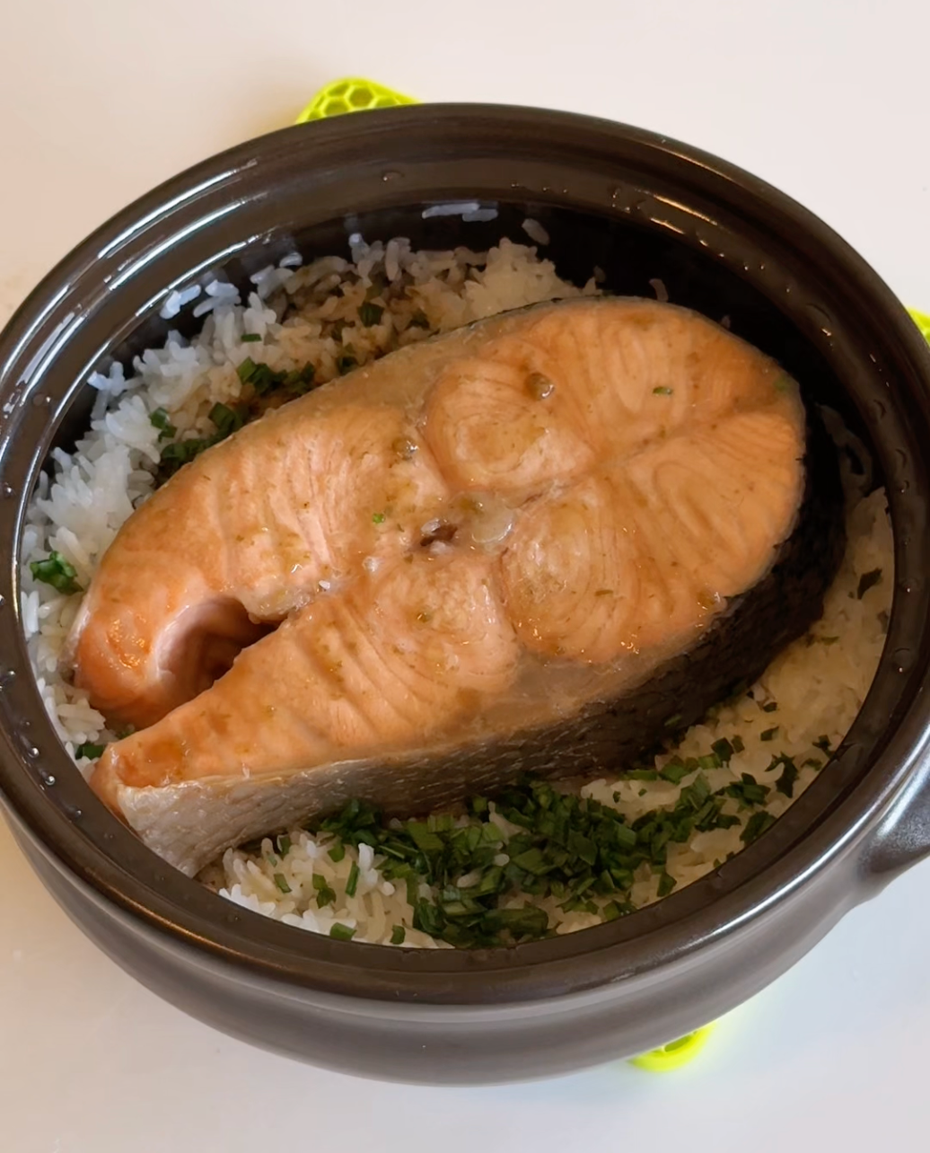 salmon in a brown clay pot of rice and chives