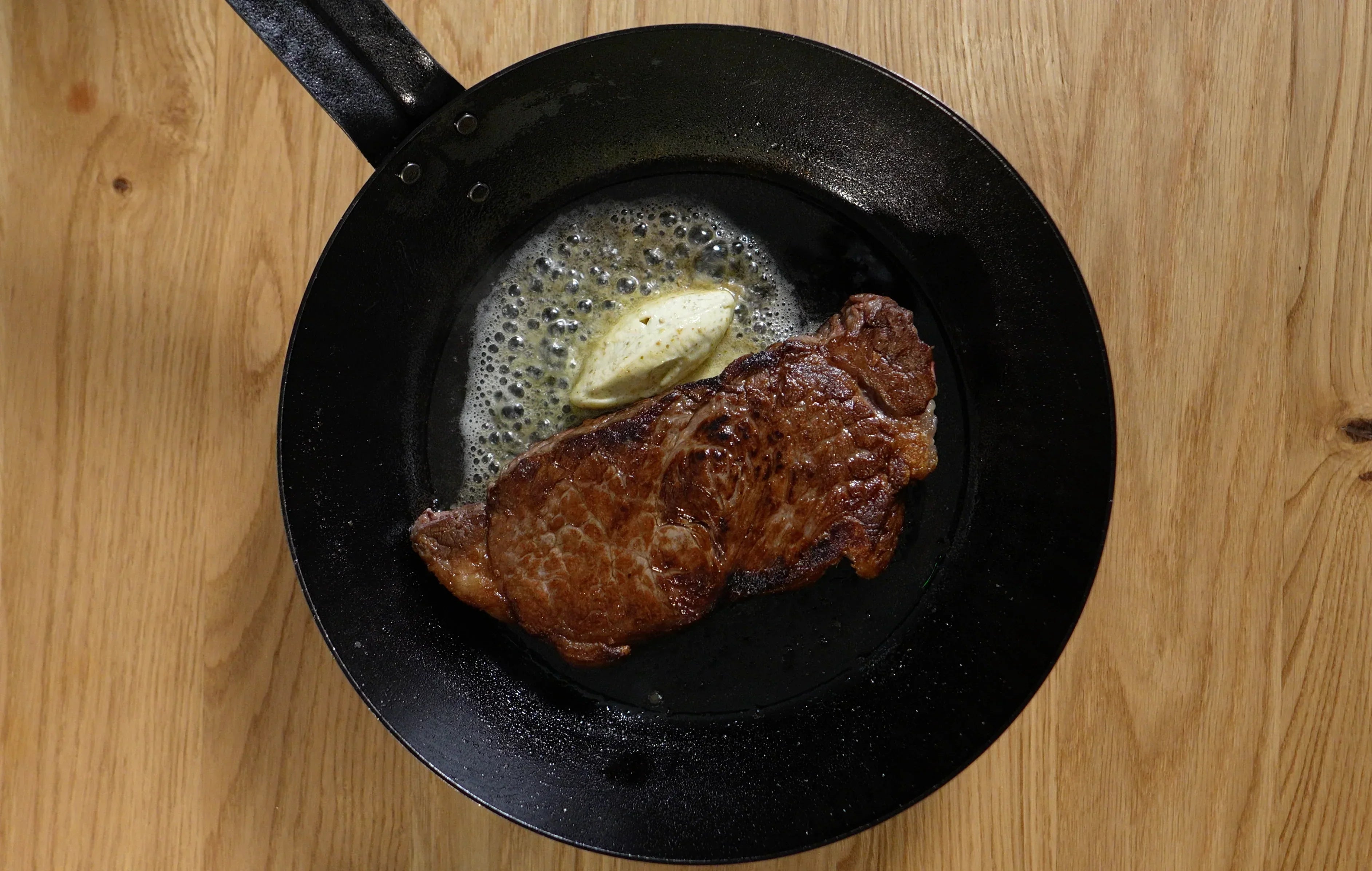 seared steak with yuzu kosho butter in a black pan