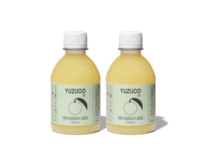 Front view of two 8oz bottles of 100 percent Sudachi juice with pale yellow liquid and YUZUCO labels on white background
