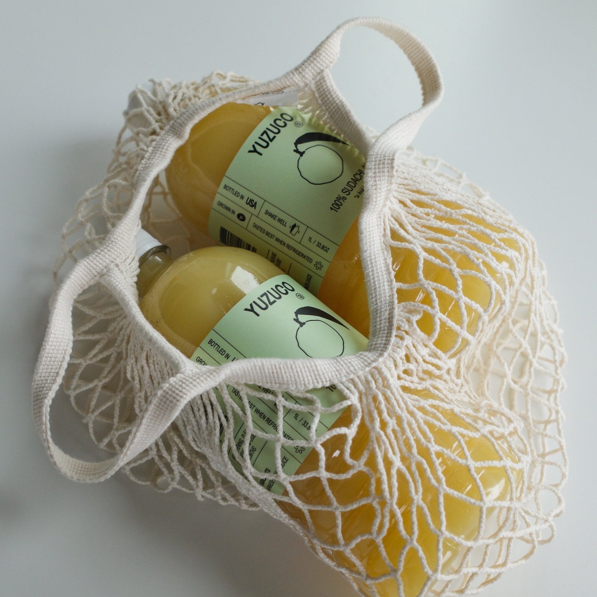 Two 1 Liter bottles of 100% Sudachi Juice in a netted bag.
