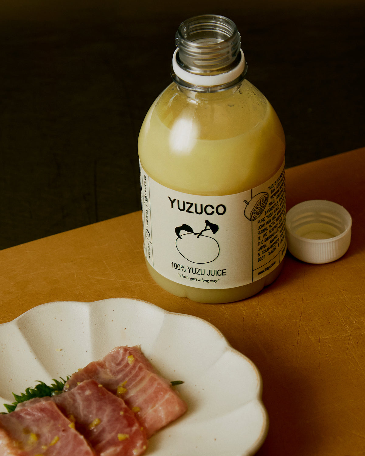 Yuzuco 100% Yuzu Juice on counter next to tuna sashimi