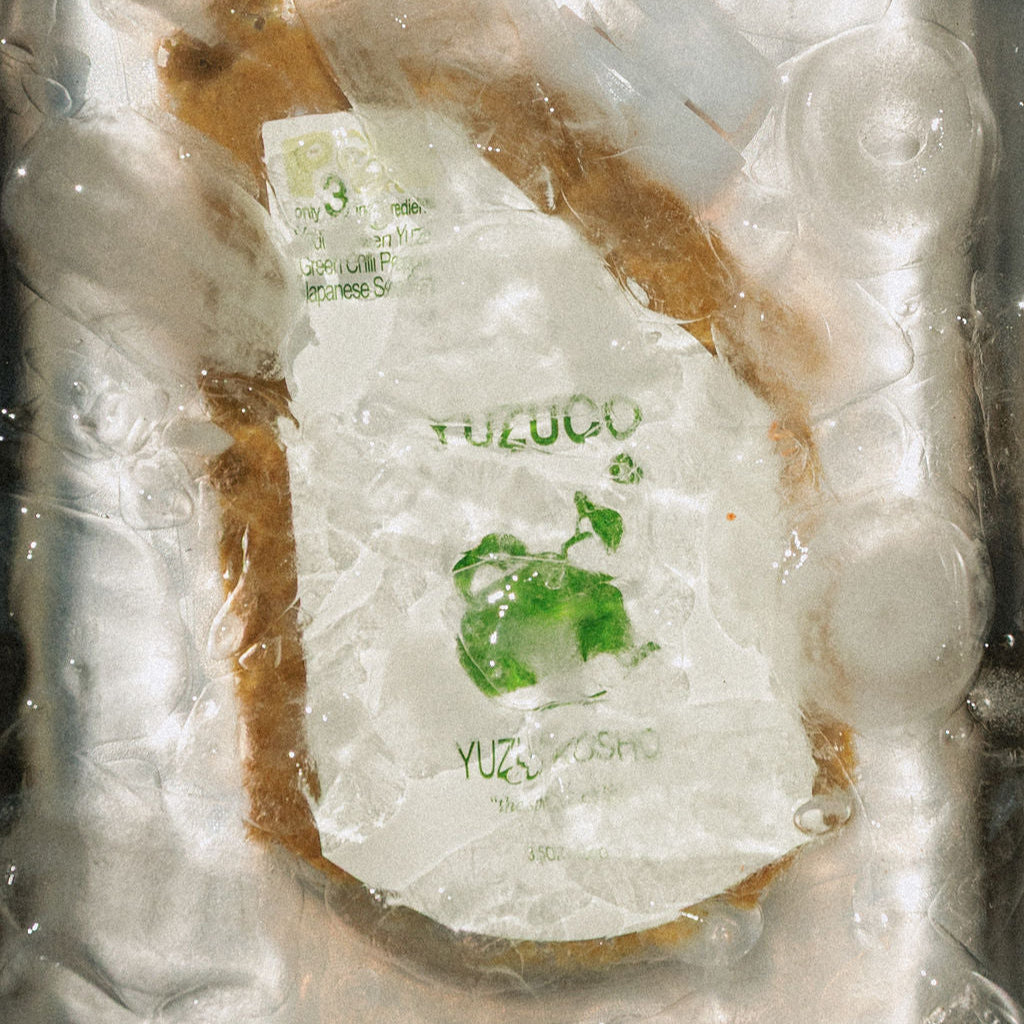 YUZUCO Green yuzu kosho submerged in ice water in a metal tray 