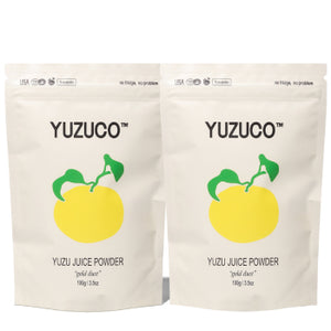Front view of two Yuzu Juice Powder pouches showcasing YUZUCO logo and resealable stand-up packaging on white background